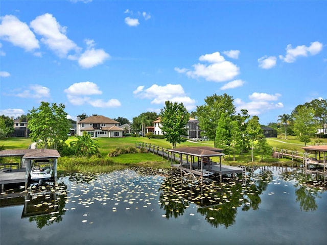 dock with a water view, a yard, and boat lift
