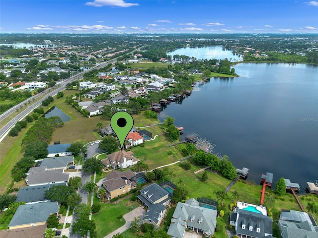 aerial view of property and surrounding area featuring a large body of water and nearby suburban area