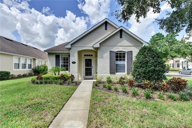 view of front of home featuring stucco siding and a front lawn