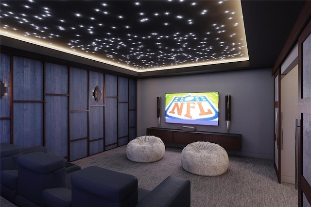 home theater room featuring carpet and a tray ceiling