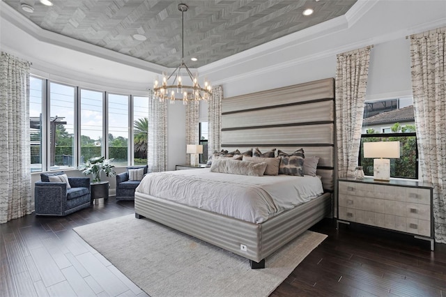 bedroom with a tray ceiling, ornamental molding, a chandelier, dark wood-style floors, and recessed lighting