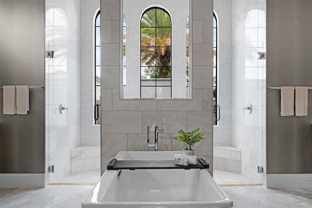 bathroom with a shower stall and baseboards