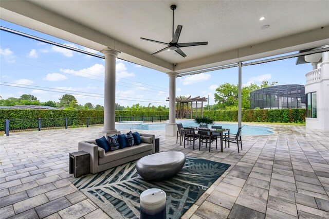 view of patio with a ceiling fan, fence, a pool with connected hot tub, and outdoor lounge area