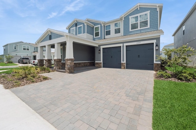 13187 Telsen St Unit 38, Winter Garden, FL 34787 - craftsman-style house with stone siding, an attached garage, decorative driveway, and a porch