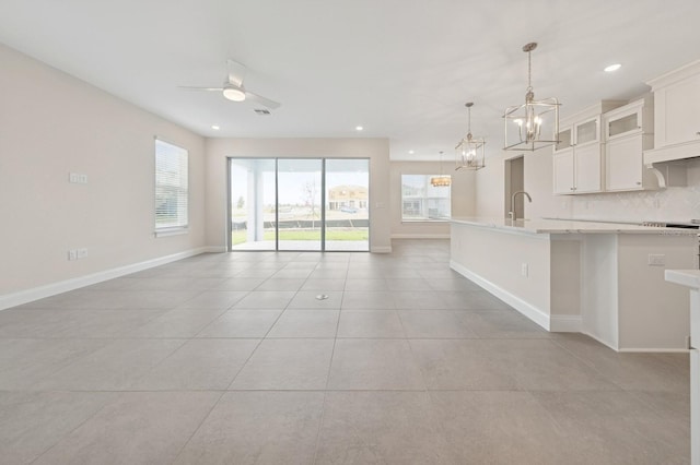 13187 Telsen St Unit 38, Winter Garden, FL 34787 - kitchen with a chandelier, open floor plan, light tile patterned floors, a center island with sink, and tasteful backsplash