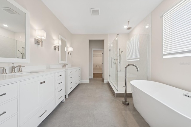 13187 Telsen St Unit 38, Winter Garden, FL 34787 - bathroom with a shower stall, double vanity, a freestanding bath, a spacious closet, and tile patterned floors