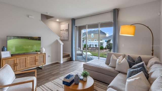 living area with stairway, wood finished floors, and baseboards