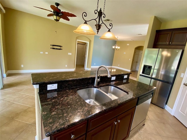 30732 Lipizzan Ter, Mount Dora, FL 32757 - kitchen with light tile patterned floors, a sink, a center island with sink, arched walkways, and appliances with stainless steel finishes