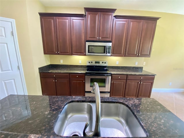 30732 Lipizzan Ter, Mount Dora, FL 32757 - kitchen featuring stainless steel appliances, a sink, dark stone counters, and tile patterned floors