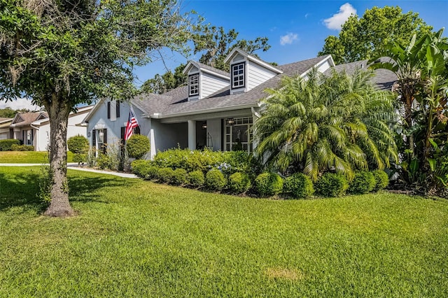 view of side of property featuring a lawn and a shingled roof