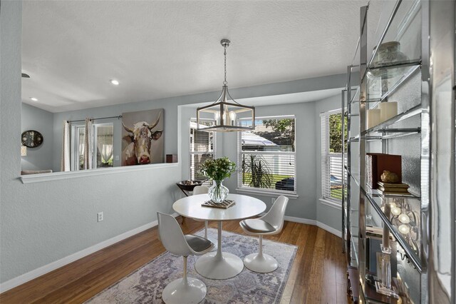 dining area featuring wood finished floors, baseboards, a chandelier, and recessed lighting