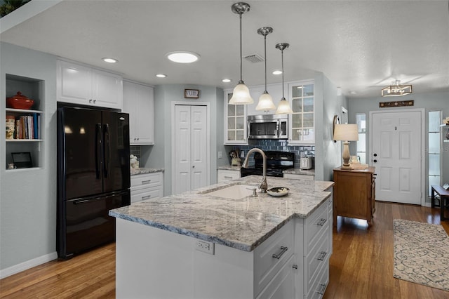 kitchen featuring black appliances, white cabinetry, backsplash, a sink, and glass insert cabinets