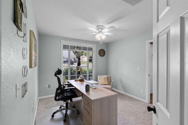 carpeted office with a ceiling fan, baseboards, and a textured ceiling