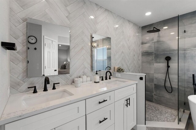 full bathroom with walk in shower, double vanity, and tile walls