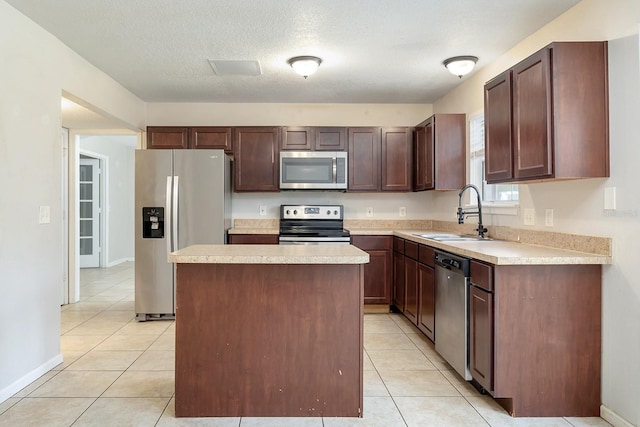 2320 Red Ember Rd, Oviedo, FL 32765 - kitchen with stainless steel appliances, a sink, light countertops, a kitchen island, and light tile patterned floors