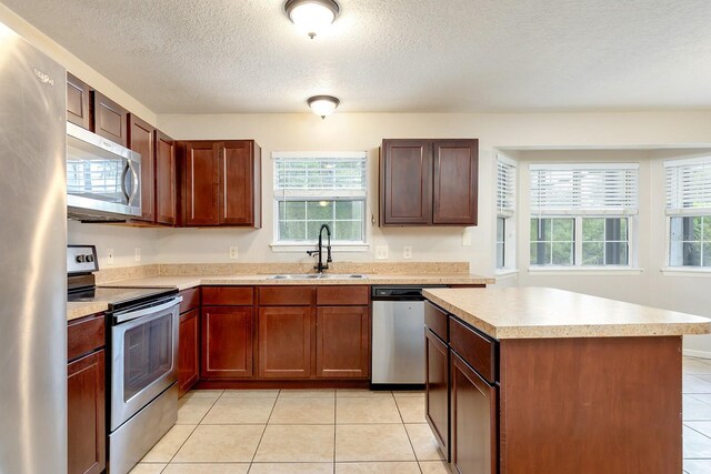 2320 Red Ember Rd, Oviedo, FL 32765 - kitchen featuring appliances with stainless steel finishes, a sink, light countertops, plenty of natural light, and a textured ceiling