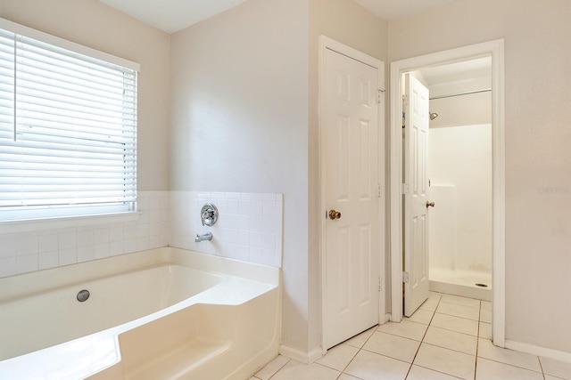 2320 Red Ember Rd, Oviedo, FL 32765 - bathroom with baseboards, tile patterned flooring, a bath, and plenty of natural light