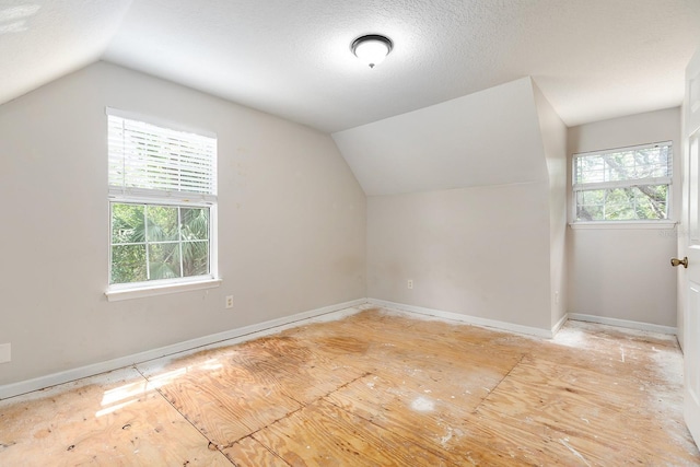 2320 Red Ember Rd, Oviedo, FL 32765 - additional living space with vaulted ceiling, baseboards, and a textured ceiling