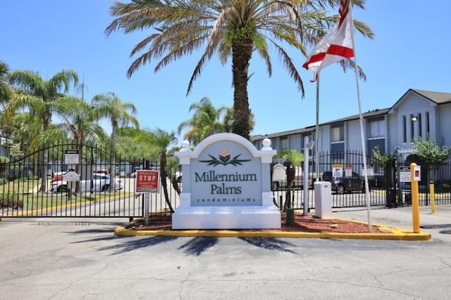 community / neighborhood sign featuring a gate and fence
