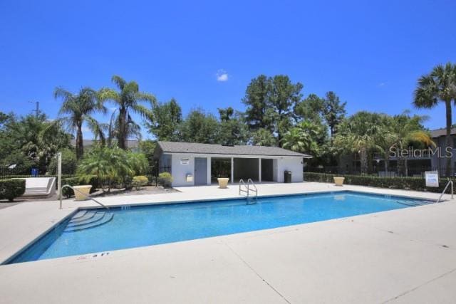 pool with a patio and fence