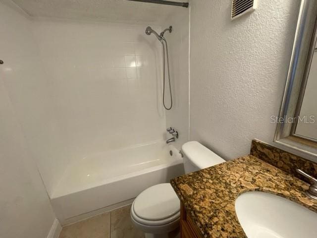 full bath with toilet, vanity, shower / tub combination, and a textured wall