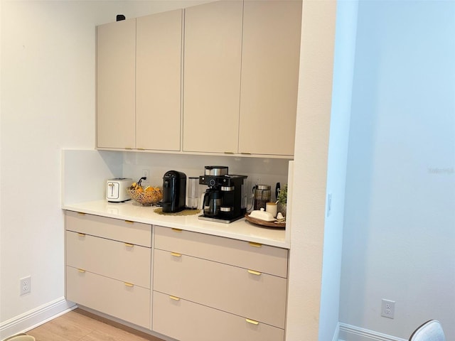 bar featuring light wood-style flooring and baseboards
