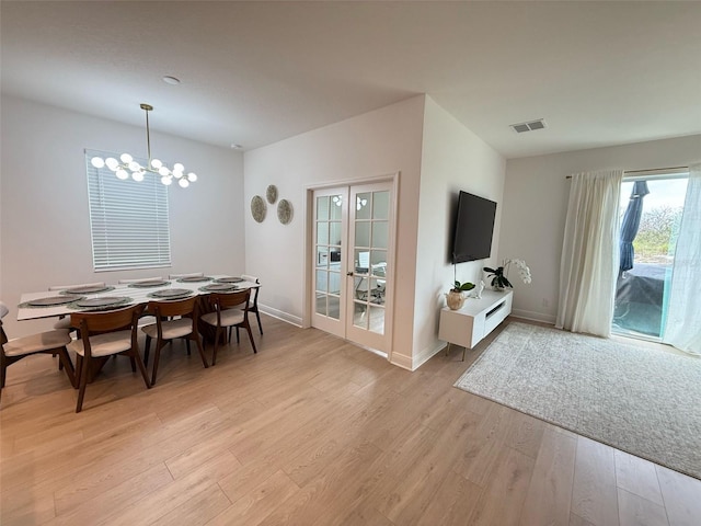 dining area with french doors, visible vents, an inviting chandelier, light wood-style flooring, and baseboards