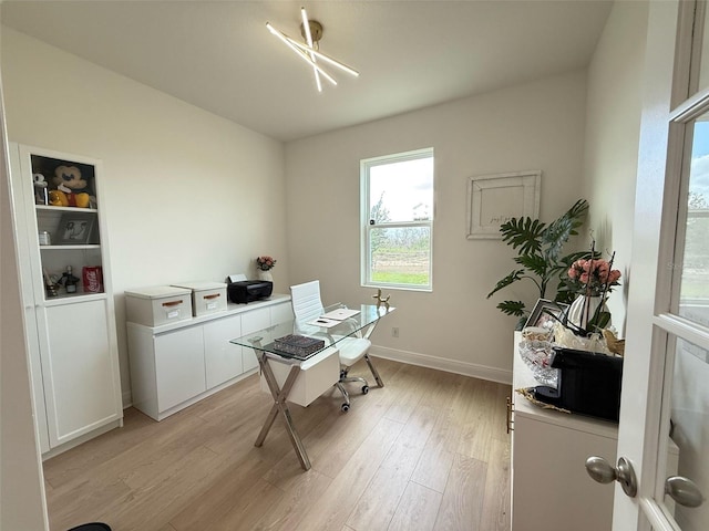 home office with light wood-type flooring and baseboards