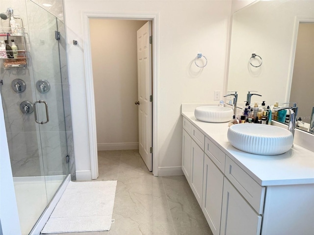 bathroom featuring a sink, baseboards, a shower stall, and marble finish floor