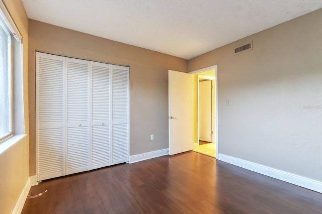 4727 S Texas Ave Unit 4727C, Orlando, FL 32839 - unfurnished bedroom featuring baseboards, a closet, visible vents, and dark wood-type flooring