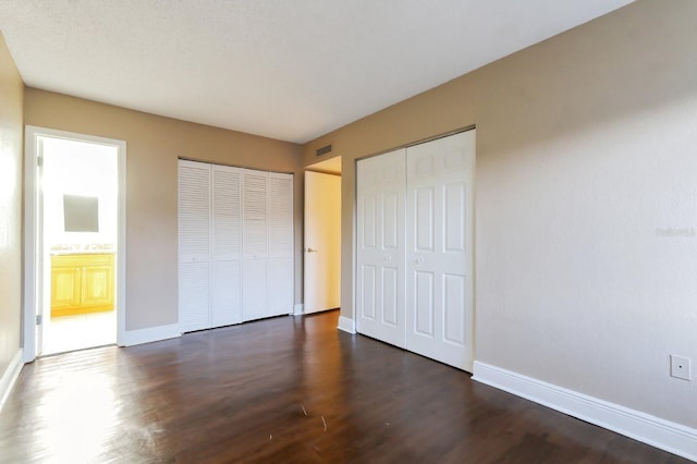 4727 S Texas Ave Unit 4727C, Orlando, FL 32839 - unfurnished bedroom with baseboards, dark wood-style floors, multiple closets, and visible vents