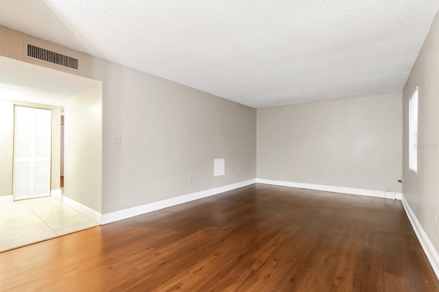 4727 S Texas Ave Unit 4727C, Orlando, FL 32839 - empty room featuring a textured ceiling, baseboards, visible vents, and wood finished floors