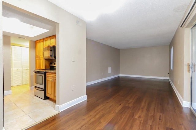 4727 S Texas Ave Unit 4727C, Orlando, FL 32839 - interior space featuring baseboards, black microwave, light wood-style floors, and electric range