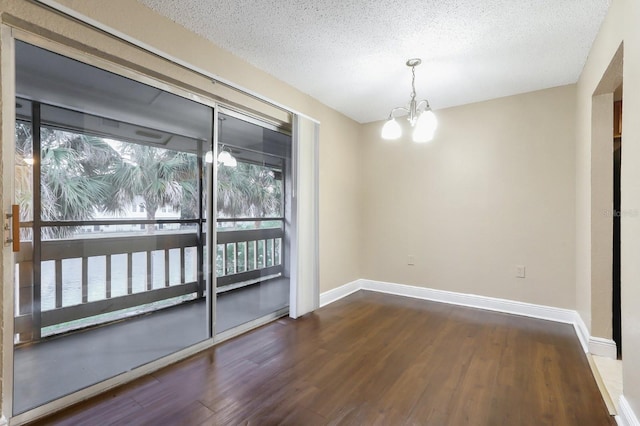 4727 S Texas Ave Unit 4727C, Orlando, FL 32839 - empty room with baseboards, a textured ceiling, a notable chandelier, and dark wood-style floors