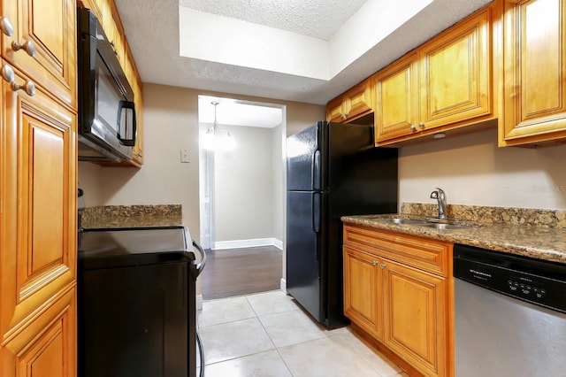 4727 S Texas Ave Unit 4727C, Orlando, FL 32839 - kitchen with a sink, brown cabinets, a textured ceiling, light tile patterned flooring, and black appliances