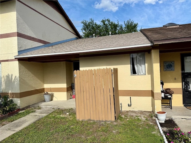 963 Stucki Ter, Winter Garden, FL 34787 - view of property exterior with a shingled roof, stucco siding, and fence