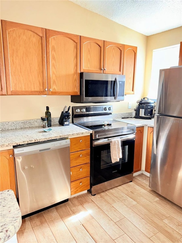 963 Stucki Ter, Winter Garden, FL 34787 - kitchen featuring stainless steel appliances, a textured ceiling, and light wood-style floors