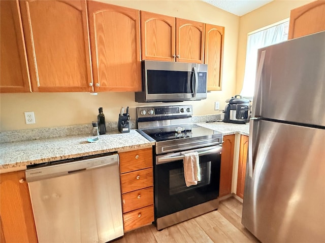 963 Stucki Ter, Winter Garden, FL 34787 - kitchen featuring light stone counters, stainless steel appliances, and light wood-style flooring