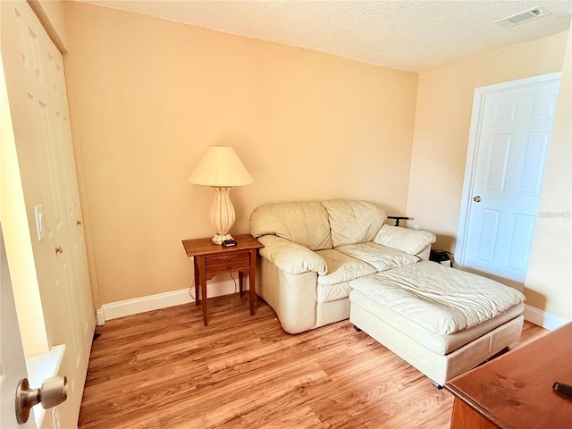 963 Stucki Ter, Winter Garden, FL 34787 - living room featuring light wood finished floors, a textured ceiling, baseboards, and visible vents