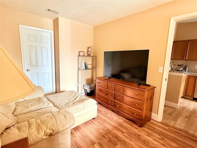 963 Stucki Ter, Winter Garden, FL 34787 - living room featuring light wood finished floors, a textured ceiling, and visible vents