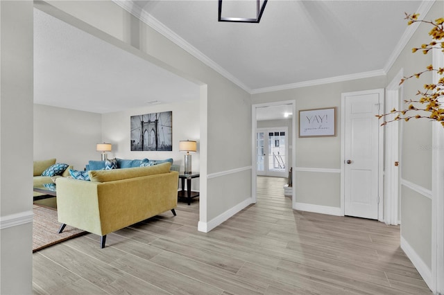 foyer featuring ornamental molding, light wood-style floors, and baseboards