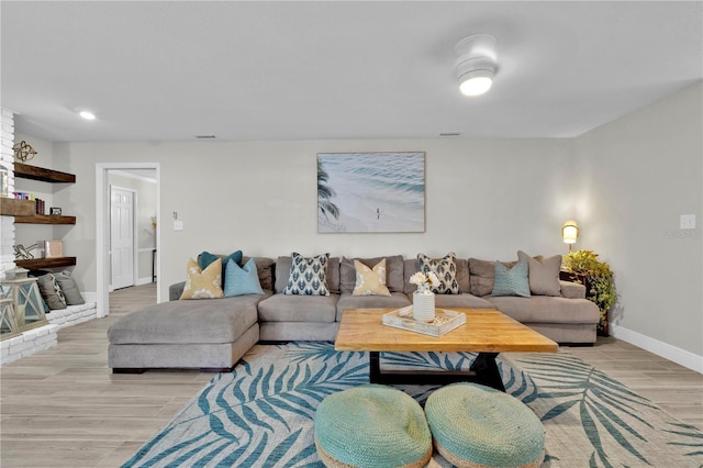 living area featuring light wood finished floors, baseboards, and recessed lighting