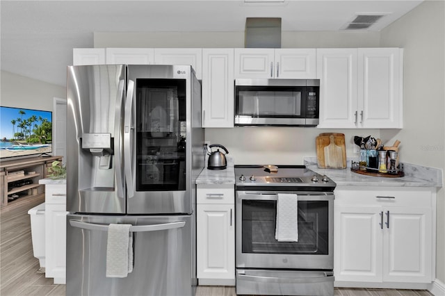 kitchen with visible vents, white cabinets, appliances with stainless steel finishes, and light stone countertops