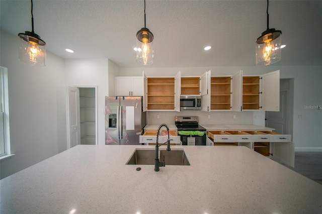kitchen featuring open shelves, stainless steel appliances, pendant lighting, and a sink