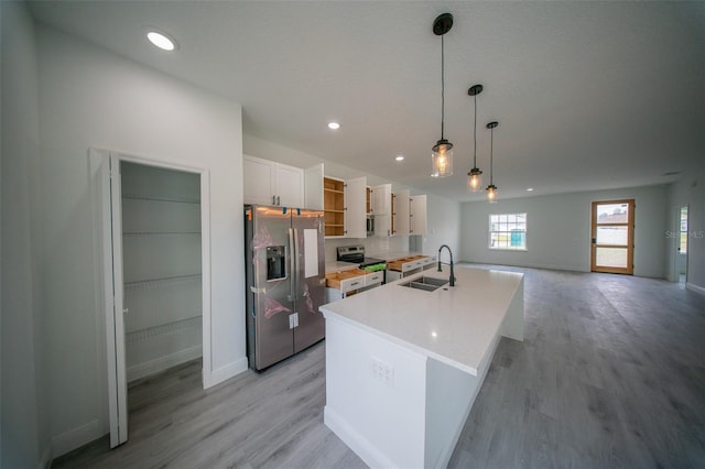 kitchen featuring a sink, stainless steel appliances, open shelves, light wood finished floors, and white cabinetry