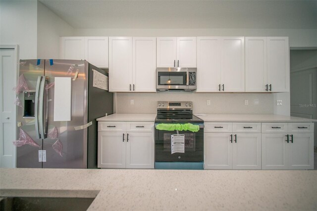 kitchen featuring light countertops, white cabinets, and appliances with stainless steel finishes