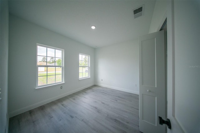 spare room featuring baseboards, recessed lighting, visible vents, and wood finished floors