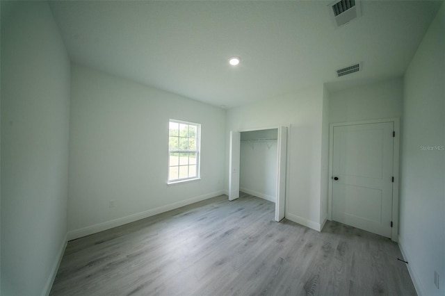 unfurnished bedroom with baseboards, visible vents, and wood finished floors