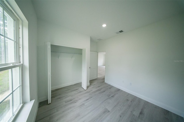unfurnished bedroom featuring light wood-style flooring, recessed lighting, visible vents, and multiple windows