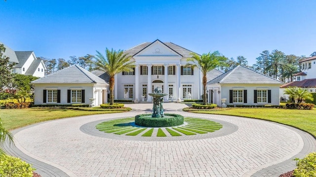 view of front facade featuring curved driveway, a front lawn, and stucco siding